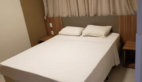 卡达斯诺瓦斯Praias do Lago Eco Resort的一张白色的床,上面有两个枕头
