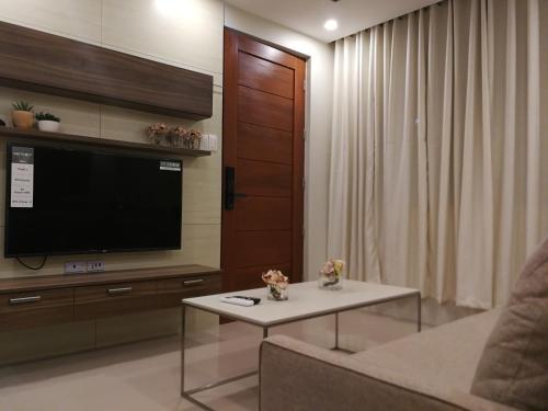 马尼拉Adria Residences - Sapphire Garden - 2 Bedroom for 4 person的客厅配有电视、沙发和桌子