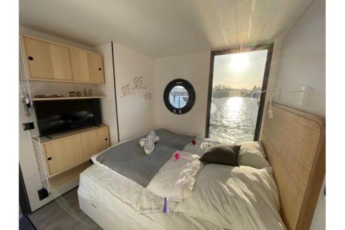 巴特Hausboot Fjord HAVEN mit Biosauna in Barth的一间卧室配有一张床,享有水景