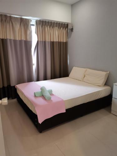 亚依淡Seri Sayang 2 Apartment suite with 2bedroom的一间卧室配有一张带粉色毯子的大床