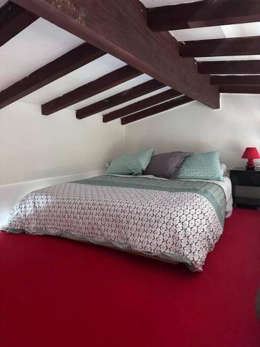 哥西尔Studio mezzanine vue mer的卧室配有一张红色地板的床