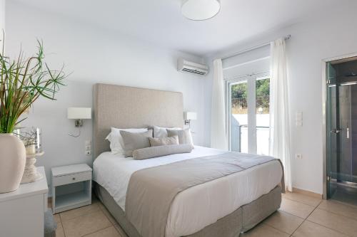干尼亚Villa Panorama的白色的卧室设有一张大床和一个窗户