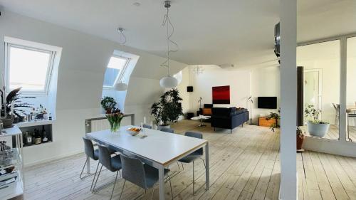 哥本哈根ApartmentInCopenhagen Apartment 158的厨房以及带桌椅的起居室。