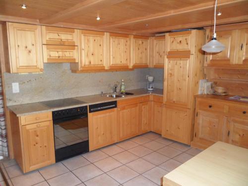 圣安特尼恩Ferienwohnung Haus Bord的一个带木制橱柜和水槽的厨房