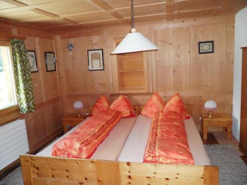 圣安特尼恩Ferienwohnung Haus Bord的一间卧室配有一张带红色枕头的床