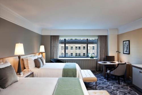 纽约纽约丽晶洛斯酒店的酒店客房设有两张床、一张书桌和一个窗户。