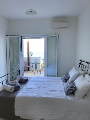 基普塞利Amaltheia Beach Front Houses的卧室设有一张大白色床和阳台