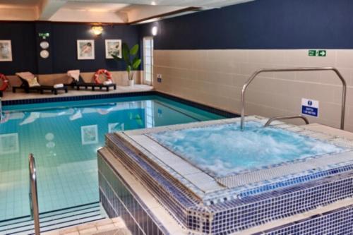 斯劳Burnham Beeches Hotel的在酒店客房内的游泳池设有热水浴池