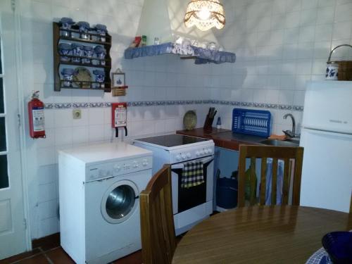 富尔纳斯Casa da Beija - House Azores的厨房配有洗衣机和冰箱。