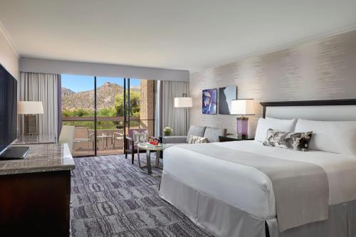 土桑洛伊斯塔纳峡谷度假酒店的一间带白色大床的卧室和一间客厅