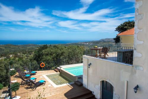 PátimaVilla Cretan View with Heated Swimming Pool的从带游泳池的房屋阳台欣赏风景