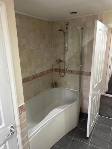 金斯布里奇The Pickwick Inn的带淋浴的浴室配有白色浴缸。