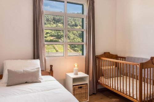 桑塔纳Casa da Olides - T3的一间婴儿卧室,配有一张婴儿床和一扇窗户