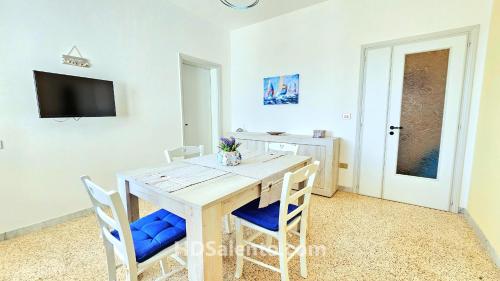 佩斯科勒海滨Casa Lores - Fronte Mare Pescoluse的一间带木桌和椅子的用餐室