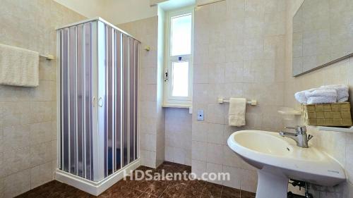 佩斯科勒海滨Casa Lores - Fronte Mare Pescoluse的一间带水槽和玻璃淋浴的浴室