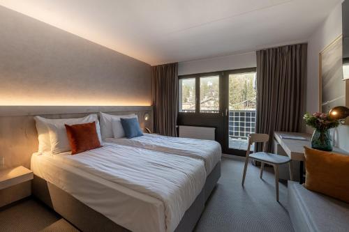 威拉尔-苏-罗伦Victoria Hotel & Residence的酒店客房设有一张大床和一张书桌。