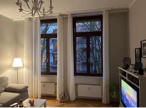 威斯巴登APT im Herzen von Wiesbaden的客厅设有2扇带白色窗帘的窗户。