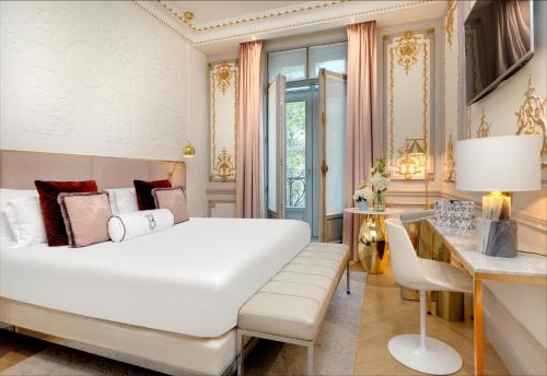 巴黎鲍曼酒店的卧室配有一张白色大床和一张书桌