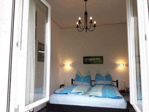 马克多夫Villa Maja的一间卧室配有一张带蓝色枕头的床和吊灯。