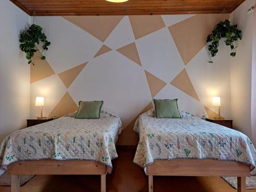 大里贝拉Mojo House的一间设有两张床的房间和墙上的两盏灯