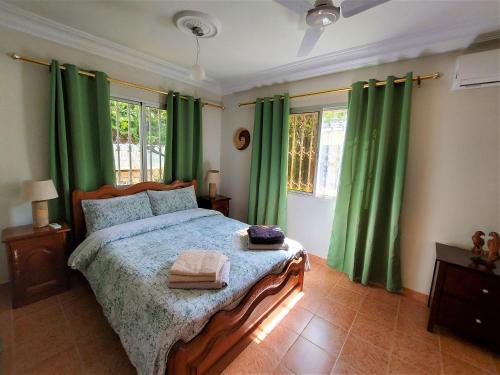 BijiloBougainvillea House的一间卧室配有绿色窗帘和一张大床