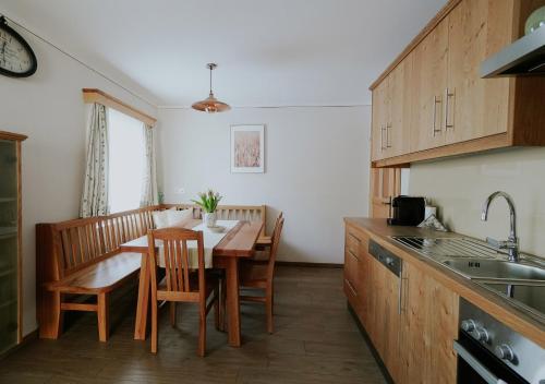 GroßkleinMühlbauerhof的一间带木桌的厨房和一间餐厅