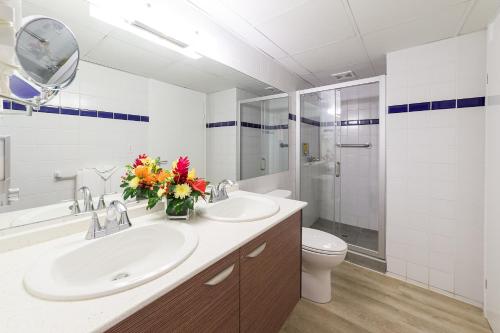 辛普森湾拉维斯塔海滩度假酒店的浴室设有2个水槽、卫生间和镜子。
