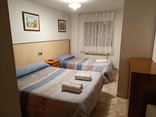 塞哥维亚塔拉伊君悦旅馆的一间卧室配有两张带毛巾的床
