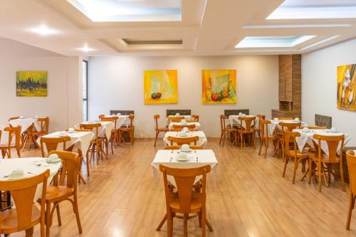 沃尔塔雷东达Dexter Hotel - Volta Redonda的一间带桌椅和绘画的用餐室