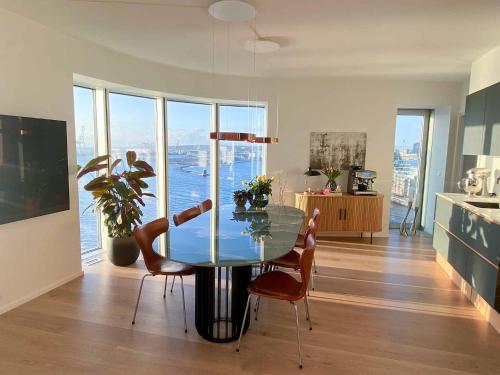 奥胡斯Amazing sea view apartment的一间设有玻璃桌和椅子的用餐室