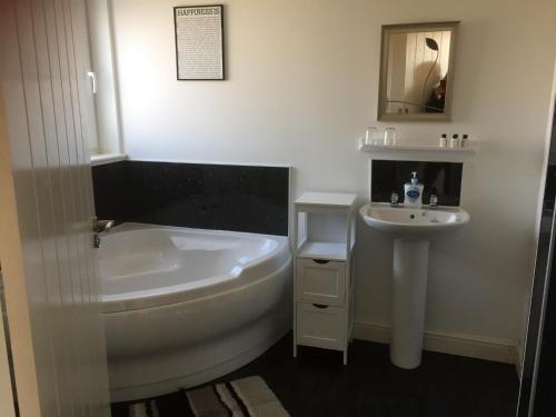 Bowmore达乌拉尔住宿加早餐旅馆的白色的浴室设有浴缸和水槽。