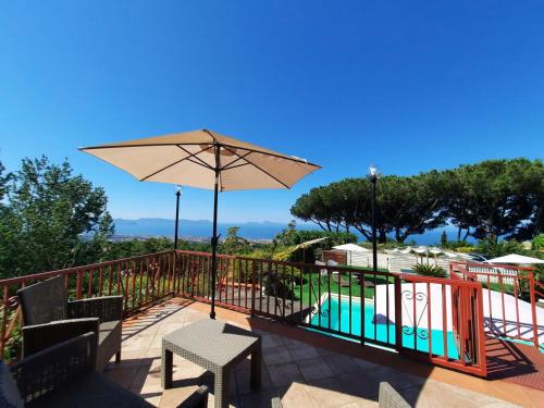 埃尔科拉诺B&B Iolì Vesuvio的一个带桌子和遮阳伞的庭院和一个游泳池