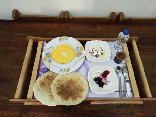 锡瓦Al-Manara Hostel Siwa Oasis的盘子上放着煎饼和其他食物