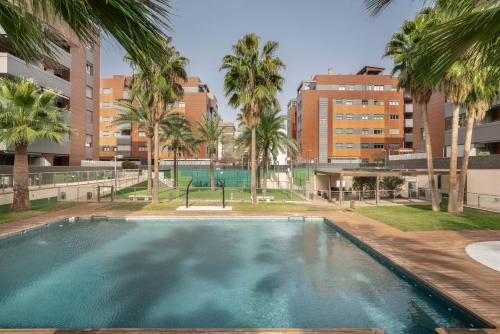 格拉纳达EnjoyGranada EMIR 4C + Parking的一个棕榈树和建筑的空游泳池