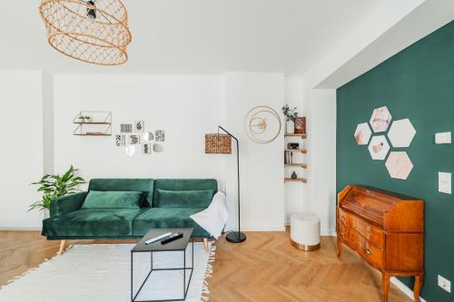 维也纳The 15's Apartments的客厅配有绿色沙发和桌子
