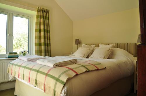 TunstallRose Cottage的一间卧室配有一张床铺,床上有毯子