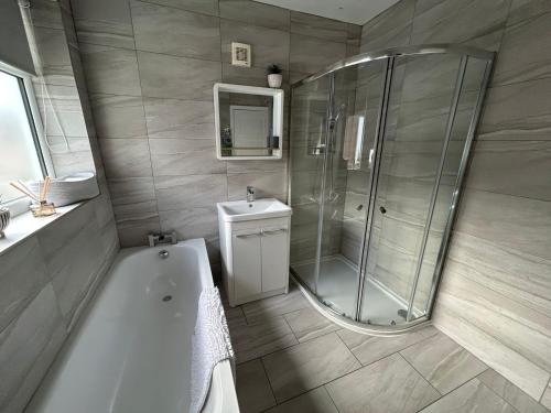 波尔顿乐法尔德Light And Spacious Highcross Apartment的带淋浴、浴缸和盥洗盆的浴室