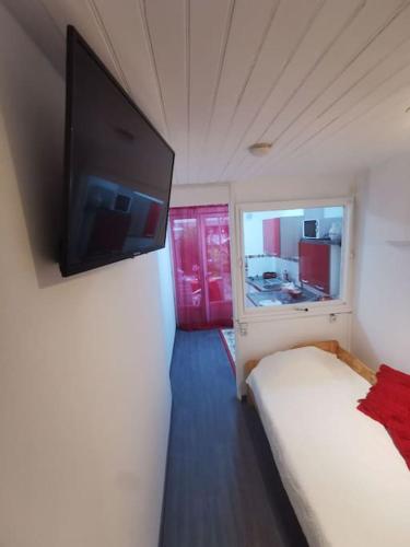 弗兰奎维尔-圣皮尔Appartement fonctionnel et équipé en RDC avec petite terrasse couverte au calme的卧室配有一张床和壁挂式平面电视。