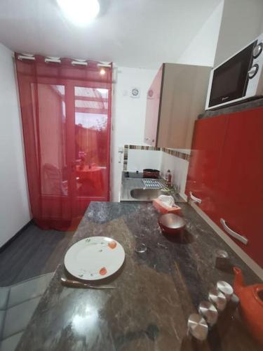 弗兰奎维尔-圣皮尔Appartement fonctionnel et équipé en RDC avec petite terrasse couverte au calme的一个带红色门柜台的厨房