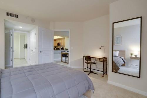 阿林顿Beautiful 2 BR Apartment At Pentagon City With Gym的一间卧室配有一张床、一张书桌和一面镜子