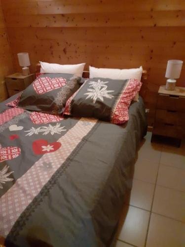 克松吕-隆日梅chalet des Greunnouilles的一间卧室配有两张带枕头的床。