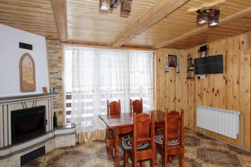 亚列姆切Cottage "Karpatske Shale"的一间带桌椅和电视的用餐室
