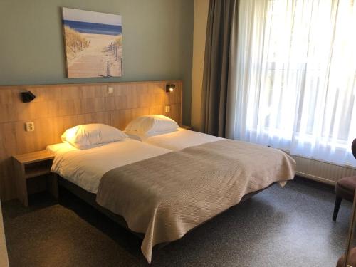 比伦Hotel "De Klok"的一间卧室设有一张大床和一个窗户。