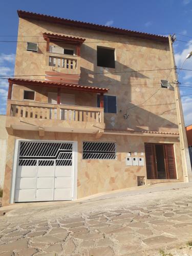 圣托梅-达斯莱特拉斯Pousada Nascer da Lua的房屋设有2扇车库门和阳台