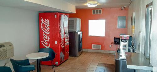 Goodland古德兰6号汽车旅馆的一间设有古柯可乐冰箱和桌子的客房