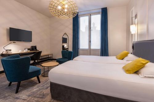 里尔Best Western Urban Hotel的酒店客房设有一张大床和一张书桌。