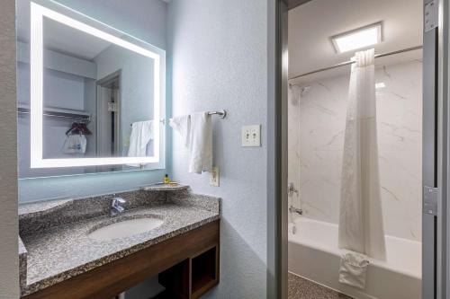 马里兰高地Best Western Plus St. Louis West-Westport的浴室配有盥洗盆、镜子和浴缸