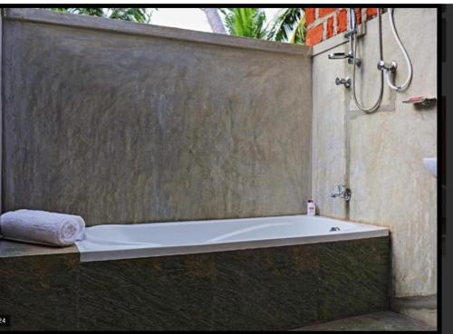 库鲁内格勒THE HIDEOUT KURUNEGALA的浴缸、淋浴和毛巾