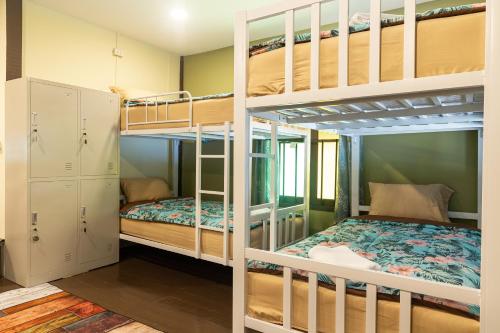 Ban Na WeBlockhouse Hostel的客房设有两张双层床和一张床。