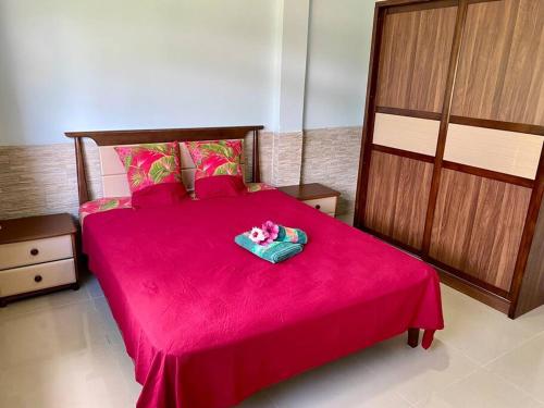 OpoaTaina - Terrasse - Bord de mer -的一间卧室配有红色的床和粉色毯子